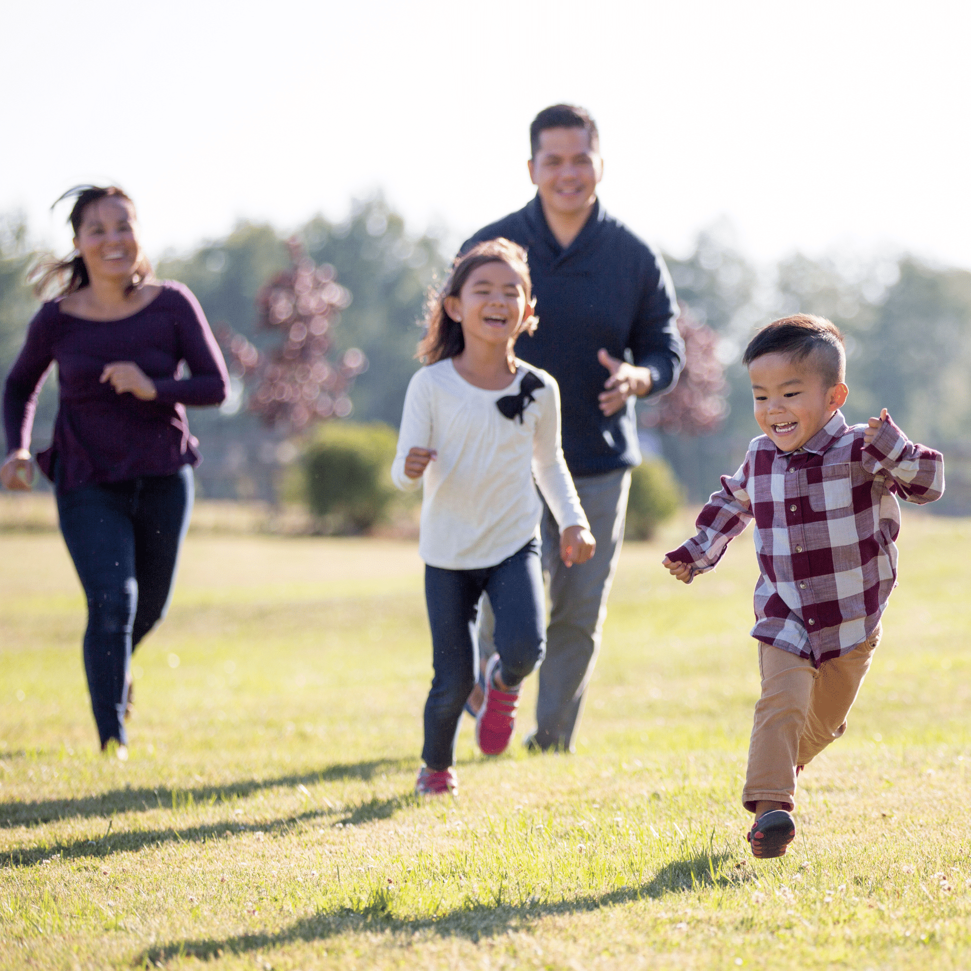 A family of four running an an open field with their free time thanks to Laundry Drop Laundry Pickup and Delivery